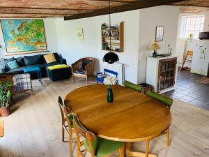 ein Esszimmer und ein Wohnzimmer mit einem Holztisch in der Unterkunft Sdr. Grønkær Bed & Breakfast in Bækmarksbro