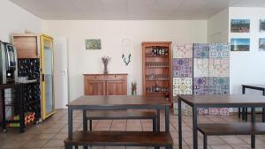 a dining room with two tables and a refrigerator at Hotel Du Rocher in Le Caylar