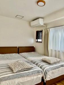 two beds sitting next to each other in a room at Grato Terrace in Tokyo
