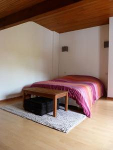 1 dormitorio con cama y mesa de madera en T3 PAYS BASQUE SUD LANDES, en Tarnos