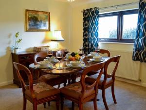 a dining room table and chairs with glasses of wine at Angerton Cottage in Kirklinton