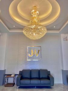 sala de estar con sofá azul y lámpara de araña en J&V Hotel and Resort, en Apaleng