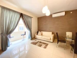 uma sala de estar com um sofá e uma mesa em Good value for money - Close to D seafront & bars em Sliema