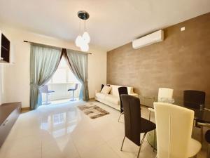 uma sala de estar com um sofá, uma mesa e cadeiras em Good value for money - Close to D seafront & bars em Sliema
