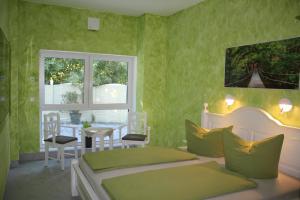 a bedroom with two beds and a table and a window at Hotel/Pension Rast& Ruh in Zodel