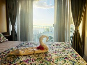 a hotel room with a swan on a bed with a window at 3 bedrooms appartement with sea view balcony and wifi at Trou aux Biches 1 km away from the slopes in Trou aux Biches