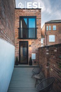 Edificio de ladrillo con 2 sillas y balcón en Contemporary Townhouse - Free Parking - Central Shrewsbury, en Shrewsbury