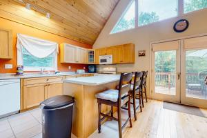 a kitchen with wooden cabinets and a large window at Mountain Retreat in Conway