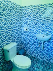a blue tiled bathroom with a toilet and a sink at Uptown Guesthouse in Siquijor +36 photos