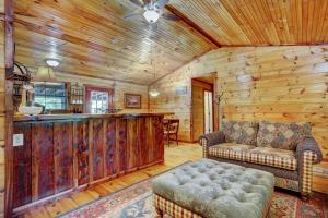 a living room with a couch and a bar in a cabin at Private Broken Bow Cabin with Hot Tub and Gazebo! in Broken Bow