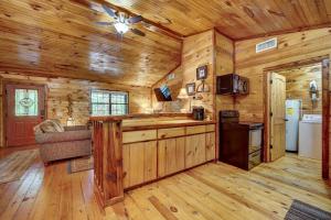 a kitchen in a log cabin with a ceiling fan at Private Broken Bow Cabin with Hot Tub and Gazebo! in Broken Bow