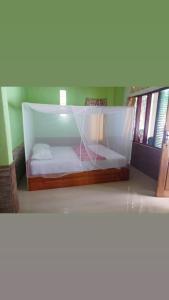 a bedroom with a bed with a net on it at Lena house Flores in Hitokalak