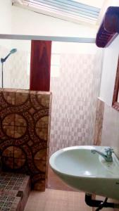 a bathroom with a sink and a bath tub at Lena house Flores in Hitokalak