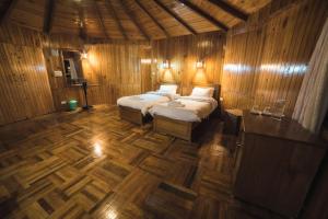 Rinchingpong的住宿－Yangsum Heritage Farm，一间卧室设有两张床,铺有木地板