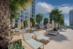 een terras met ligstoelen, parasols en tafels bij Spectacular Burj Khalifa view service apartment in Dubai