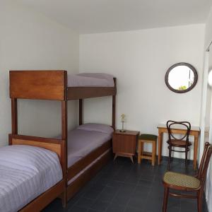 Hotel Rid في مار ديل بلاتا: غرفة نوم بسريرين بطابقين وطاولة وكرسي