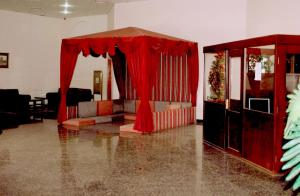 OYO 142 Al Sharqiya Sands Hotel في إبراء: غرفة معيشة مع ستارة حمراء وأريكة