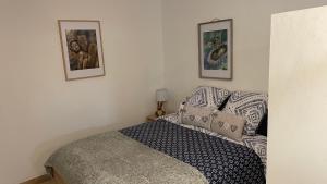 sypialnia z łóżkiem i 2 zdjęciami na ścianie w obiekcie Studio les petits lutins w mieście Entraigues-sur-la-Sorgue