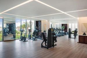 a gym with a lot of treadmills and exercise equipment at Address Beach Resort Residence Fujairah in Fujairah