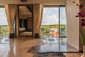 a room with a balcony with a table and chairs at Regenta Central Imperial Candolim Goa in Candolim