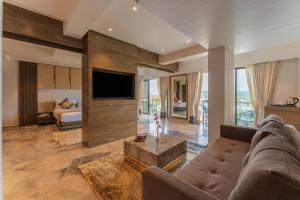 a living room with a couch and a tv at Regenta Central Imperial Candolim Goa in Candolim