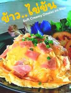 a plate of food with a omelet with ham and cheese at Mango House in Sukhothai