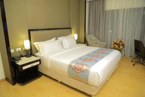 una camera d'albergo con un grande letto e una scrivania di Check Inn Hotel Addis Ababa ad Addis Abeba