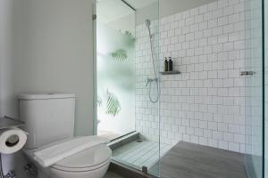 a bathroom with a toilet and a glass shower at GalileOasis Boutique Hotel in Bangkok