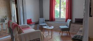 een woonkamer met een bank, stoelen en een tafel bij Combe Belle in Vézac