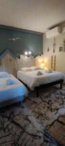 a bedroom with two beds and a wall at Résidence LE11B in Uzerche