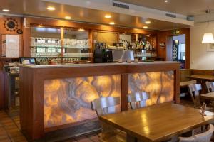 un ristorante con bar in legno con tavoli e sedie di Hotel-Restaurant Eyholz a Visp