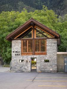 eine kleine Bar mit einem Steingebäude mit einem Holzdach in der Unterkunft Hotel-Restaurant Eyholz in Visp