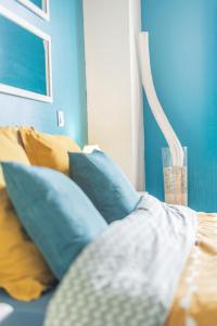 ein blaues Zimmer mit einem Bett mit blauen Kissen in der Unterkunft Private & Comfortable Apartments in Puttelange-aux-Lacs