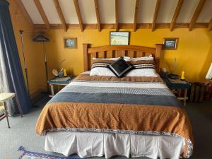um quarto com uma cama de madeira e 2 mesas em Cubby House Stay Kaikoura em Kaikoura