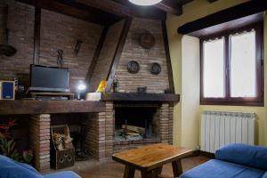 a living room with a fireplace and a tv at Casa Rural Senperenea I Landetxea in Irurita
