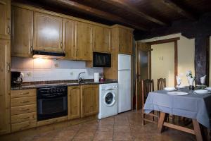 a kitchen with wooden cabinets and a table with a tableablish at Casa Rural Senperenea I Landetxea in Irurita