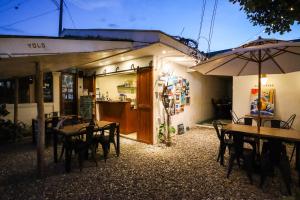 um restaurante com mesas e cadeiras e um guarda-sol em Ocean Breeze Hostel by Daily Sweet em Moalboal