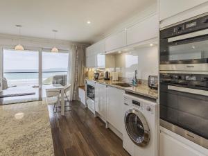 a kitchen with a washer and dryer at Apartment 18, Burgh Island Causeway in Kingsbridge