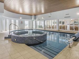 a large swimming pool with a large tub in a building at Apartment 18, Burgh Island Causeway in Kingsbridge