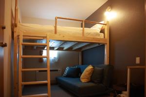 THE STAY WAKKANAI في واكاناي: سرير بطابقين مع أريكة في الغرفة