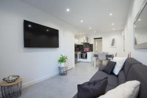 a living room with a couch and a tv on a wall at Maison de ville à proximité du centre historique in Villeneuve-lès-Avignon +11 photos
