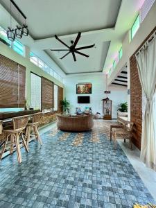 een grote woonkamer met een plafondventilator bij Adagaya Villa Langkawi - Private Pool Villa in Pantai Cenang