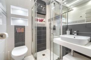 a bathroom with a toilet and a sink and a shower at Villa Atlantis in Grzybowo