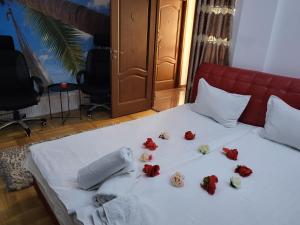 Una cama con rosas rojas y toallas. en Lights Spa National Arena Mega Mall Monza, en Bucarest