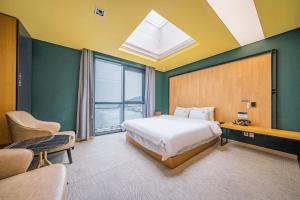 a bedroom with a bed and a large window at Louis Boutique Hotel in Changwon