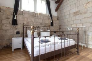 a bedroom with a metal bed in a brick wall at Ferienwohnung mit Brunnen in Quedlinburg