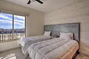 two beds in a bedroom with a large window at Luxe Cabo Casa w/ Own Rooftop Patio + Pool Access! in Cabo San Lucas