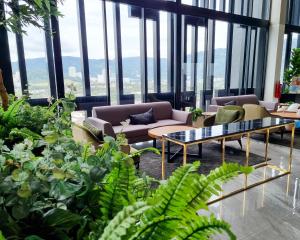 een woonkamer met een bank en een aantal planten bij Lavish Beacon Executive Suites by Bin Dao Wu Homestay Penang in George Town