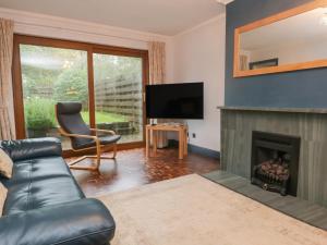 a living room with a couch and a fireplace at Ravenglass Retreat in Ravenglass