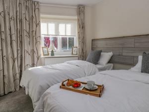 a hotel room with two beds with a tray of fruit at Endgill Cottage in Ulverston